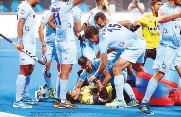  ??  ?? Indian players celebrate with goalkeeper Akash Chikte after they beat Belgium in the penalty shoot-out.