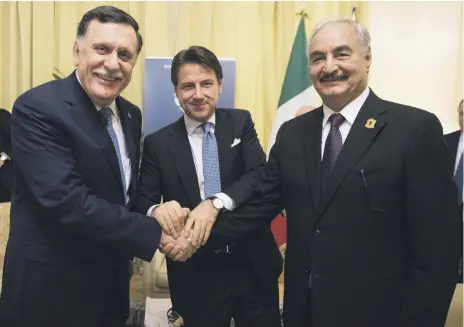  ?? EPA ?? Italian Prime Minister Giuseppe Conte, centre, shakes hands with Libyan rivals Field Marshal Khalifa Haftar, right, and Prime Minister Fayez Al Sarraj at a summit in Palermo, Italy. It was the two Libyan leaders’ first meeting in more than five months