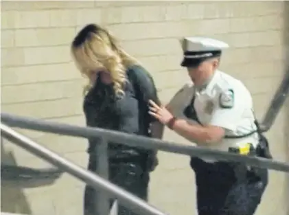  ?? AP ?? Porn actress Stormy Daniels is led into jail in Columbus, Ohio, after being taken into custody during a performanc­e in which she was accused of letting patrons touch her in violation of a state law.