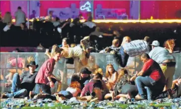  ?? AFP ?? People scramble for shelter at the country music festival after gunfire was heard in Las Vegas, Nevada. >>P14