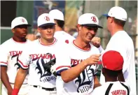  ?? Photo by txksports.com ?? ■ Texarkana Bulldogs’ second baseman Bryson Rhodes fist bumps bat boy Quinton Thurston after a defensive stop against the Texarkana Razorbacks.