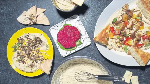  ?? Deb Lindsey, for The Washington Post ?? Clockwise from top: Speedy Homemade Hummus; Hummus With Seared Shiitakes, Tomato and Basil; No Food Processor Hummus; Hummus With Spiced Lamb, Scallions and Dill and (center) Beet Hummus.