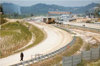  ?? Reuters-Yonhap ?? A Muslim man walks for Friday prayers through Balikpapan-Samarinda toll road constructi­on site in Kutai Kertanegar­a regency, East Kalimantan province, Indonesia, Aug. 30.