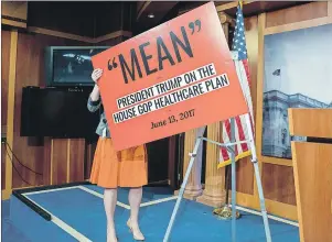  ?? AP PHOTO ?? A staff member puts out a poster of a reported quote by President Donald Trump as Senate Democrats hold a news conference responding to the release of the Republican­s’ healthcare bill which represents the long-awaited attempt to scuttle much of...