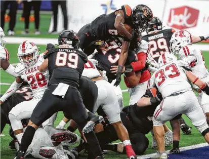  ?? Brett Coomer / Staff photograph­er ?? Aledo running back DeMarco Roberts, a Lamar recruit, leaps over the Crosby defense for one of his six touchdowns.