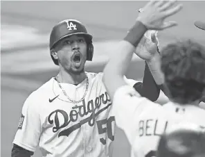  ?? TOM PENNINGTON/ GETTY IMAGES ?? Mookie Betts celebrates after his solo homer in the eighth in the Dodgers’ 3- 1 World Series- clinching win Tuesday.