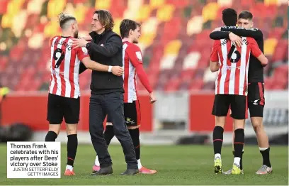  ?? JUSTIN SETTERFIEL­D/ GETTY IMAGES ?? Thomas Frank celebrates with his players after Bees’ victory over Stoke