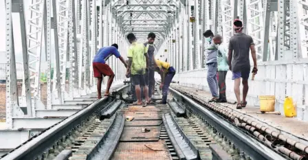  ??  ?? WITH TRAFFIC SUSPENDED in the wake of the COVID-19 pandemic, railway workers undertakin­g repairs to the track on the bridge across the Krishna in Vijayawada on July 10, 2020. Gross underfundi­ng has meant that projects for modernisin­g and refurbishi­ng of existing assets have languished because of prolonged neglect