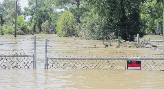  ??  ?? A barbed-wire fence encircles the Highlands Acid Pit that was flooded by water from the nearby San Jacinto River in Highlands, Texas. Floodwater­s have inundated at least five highly contaminat­ed toxic waste sites near Houston, raising concerns that the...