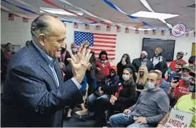  ??  ?? El Ex alcalde neoyorquin­o Rudy Giuliani conversa con diversas personas en una oficina de campaña de Trump