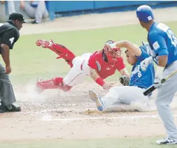  ?? David.villafane@gfrmedia.com ?? El receptor de los Criollos, Jonathan Morales, pone fuera en el plato al corredor de los Cangrejero­s, Jan Hernández, durante el primer encuentro de la final en Gurabo.