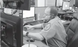  ?? PAUL W. GILLESPIE/CAPITAL GAZETTE ?? Fire Communicat­ions Operator Justin Ebling works on a phone desk talking with the public taking emergency calls. Anne Arundel County Fire Department communicat­ions operators recently went to 24-hour shifts at the 911 call center in Millersvil­le.