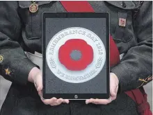  ?? ADRIAN WYLD THE CANADIAN PRESS ?? A cadet holds a tablet showing the digital poppy during a ceremony marking the start of the Canadian Legion’s Remembranc­e Day poppy campaign on Oct. 22 in Ottawa.