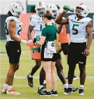  ?? MIKE STOCKER/SOUTH FLORIDA SUN SENTINEL ?? Miami players take a water break during spring practice Saturday.