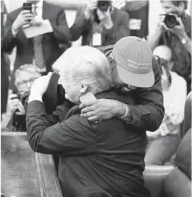  ?? POOL/GETTY IMAGES ?? Rapper Kanye West hugs U.S. President Donald Trump during a meeting in the Oval office of the White House on Oct. 11.