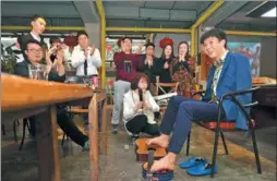  ?? GUO ZHIJUN / FOR CHINA DAILY ?? Liu Tao, an armless singer, plays guitar with his toes for young profession­als of a startup who reside at the You+ internatio­nal apartment in Guangzhou.