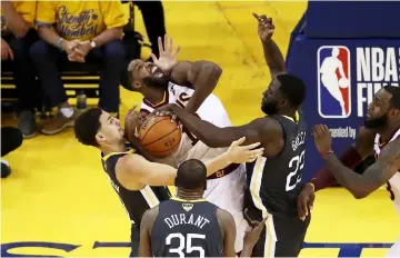  ??  ?? Klay Thompson (left) and Draymond Green (second right) of the Golden State Warriors defend Tristan Thompson of the Cleveland Cavaliers during the second quarter in Game 2 of the 2018 NBA Finals at ORACLE Arena in Oakland, California. — AFP photo