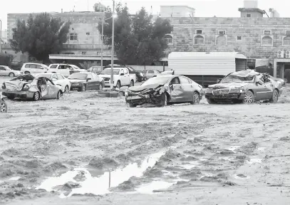  ?? — Gambar AFP ?? REMUK: Puluhan kereta rosak selepas banjir kilat susulan hujan lebat di tempat parkir daerah al-Fahahil, selatan Kuwait City kelmarin.