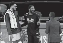  ?? MICHAEL DWYER/AP PHOTO ?? Kyrie Irving of the Brooklyn Nets, center, talks with Jayson Tatum, left, and Kemba Walker of the Boston Celtics following a game on Dec. 25 in Boston.