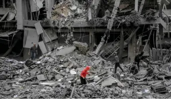  ?? — AFP photo ?? Palestinia­ns search for their belongings amid the rubble of houses destroyed by Israeli bombardmen­t in Gaza City amid the ongoing conflict between Israel and the Hamas movement.