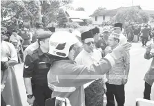  ??  ?? TAKLIMAT: Seorang pegawai bomba memberi penerangan kepada Abang Johari yang turut melawat lokasi kejadian semalam.