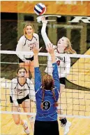  ?? [PHOTO BY NATE BILLINGS, THE OKLAHOMAN] ?? Edmond Memorial’s Annie Davis hits the ball over the net as Stillwater’s Esther Ford defends on Monday night during the Class 6A state volleyball tournament at Crossings Christian School.