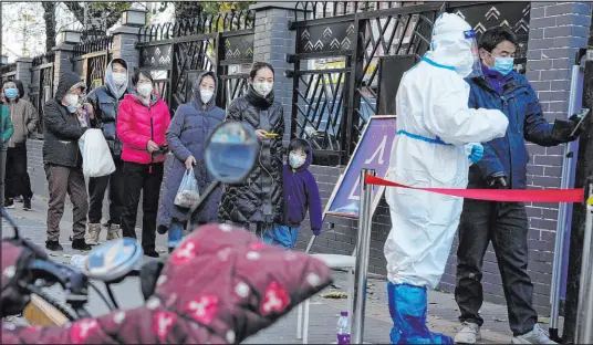  ?? Ng Han Guan The Associated Press ?? Residents line up Saturday for COVID-19 tests in Beijing, where authoritie­s reported 2,454 new COVID-19 cases in 15 hours.