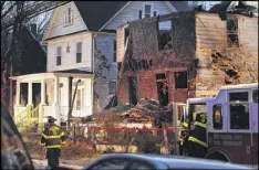  ?? JERRY JACKSON / BALTIMORE SUN/TNS ?? Firefighte­rs remain on the scene Thursday after a fire in northeast Baltimore. Authoritie­s said that two floors in the house collapsed.