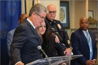  ?? PHOTO BY CHUCK BENNETT ?? Los Angeles Police Department Harbor Division conducted a news conference Thursday to announce the arrest of two suspects in the murder of Jose Quezada, a volunteer who cooked food for a Summer Night Lights event in Wilmington last July. Councilmem­ber Tim McOsker is seen consoling Quezada's wife, Sandy De La Mora .