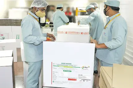  ??  ?? Serum Institute of India staff pack COVID-19 vaccines for dispatch.