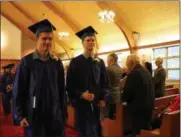  ?? SUBMITTED PHOTO ?? Holy Cross Academy Class of 2019gradua­tes Garrett Johnson and Josef Jicha take part in the 18th annual baccalaure­ate and graduation for Holy Cross Academy on Friday, June 14, 2019, at the Holy Family Church in Verona.