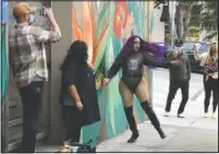  ?? (AP/Haven Daley) ?? Amoura Teese (center) performs on a sidewalk for customers in San Francisco.