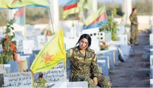  ?? — Reuters ?? Fighters of Syrian Democratic Forces visit the graves of their late comrades at a cemetery in Kobani, Syria.