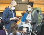  ?? Associated Press ?? People check their phones after arriving on a flight from Europe at Logan Internatio­nal Airport in Boston on Friday.