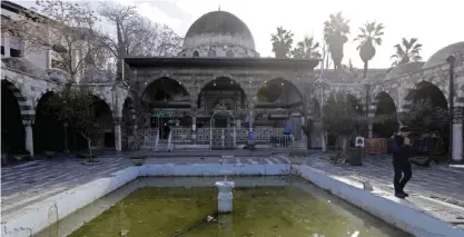  ?? — AFP ?? DAMASCUS: A general view shows artisan workshops in a historic Ottoman building with a fountain in the courtyard filled with dirty water in the capital.