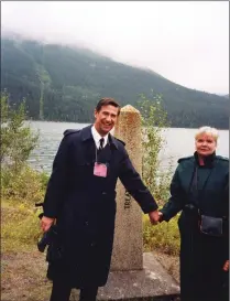  ?? Galt Archives photo 2003100221­2 ?? District 5360 Governor Dan Graham grasps the hand of Mrs. Budge, wife of District 5390 Governor Bruce Budge, on Sept. 13, 1997 during the “Hands Across the Border” ceremony, part of the Waterton-Glacier Peace Park Assembly.