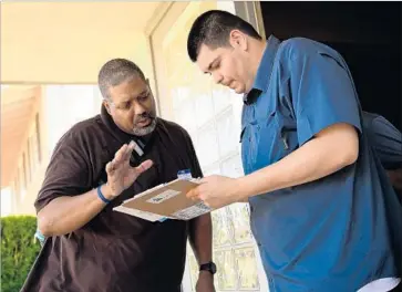  ?? Photograph­s by Christina House For The Times ?? DEREK BRYSON, left, a Democratic volunteer from Culver City, helps Simi Valley resident Erick Guillen, 25, sign up to vote by mail. Democrats are targeting the seat of second-term Republican Rep. Steve Knight.