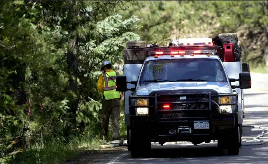  ?? MATTHEW JONAS/STAFF PHOTOGRAPH­ER ?? Boulder County Sheriff’s Fire Management crews are seen near the 11000Block of Lefthand Canyon Drive in Boulder County on Monday, July 18, 2022. Four people are confirmed dead after a twin-engine plane crash Sunday morning that sparked a small wildfire in the area between Lefthand Canyon Drive and Gold Hill Road.