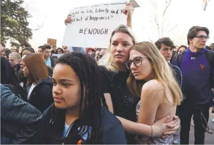  ?? Andy Cross, The Denver Post ?? Denver South students Tillie Pinkowitz, left, and Hannah Hall embrace during Wednesday’s walkout protesting gun violence.