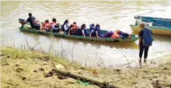  ?? ?? SK Dandun pupils crossing the Sungai Bengkoka to attend class.