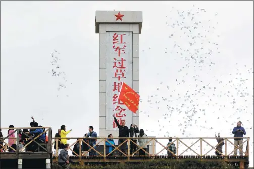  ?? HUA XIAOFENG / FOR CHINA DAILY ?? A group of journalist­s hold a memorial ceremony at a Long March monument in Hongyuan county, Sichuan province, on Sept 13. The group was invited by China’s internet watchdog to retrace the route of the Red Army’s 12,500-km Long March.