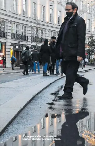  ??  ?? A shopper walks the streets of London ahead of new restrictio­ns.