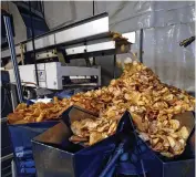  ?? STAFF / FILE ?? Freshly seasoned potato chips tumb le into the bagging machine at Mikesell’s. The chip company has been
recommende­d for an ED/GE grant.