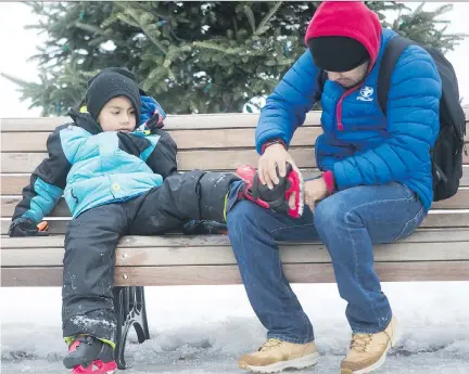 ?? PIERRE OBENDRAUF ?? Six-year-old Emiliano Eloy gets help from his dad Miguel Eloy with tying his skates at the refrigerat­ed ice rink at Beaver Lake on Dec. 27. But on New Year’s Day skaters couldn’t warm up or enjoy a hot beverage inside the pavilion, which was closed on...