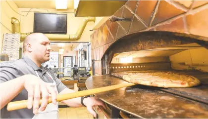  ?? APRIL GAMIZ/THE MORNING CALL ?? Sal Dewalt makes a pizza Wednesday at his restaurant, Salvatore Ruffino’s Pizza, in Allentown. Despite having never made a pizza before, Dewalt took the restaurant over after the unexpected death last year of his father.