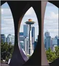  ?? ?? The Space Needle is framed through the steel sculpture ‘Changing Form,’ by Doris Totten Chase, May 10, at Kerry Park in Seattle. The roof of the Seattle icon has been painted its original color of ‘galaxy gold,’ in honor of the attraction’s 60th anniversar­y and the color will remain for the coming year. (AP)