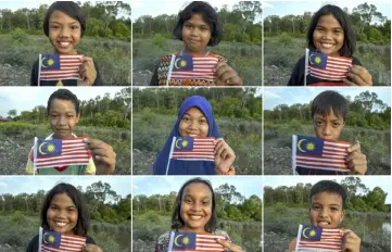  ??  ?? Portraits of Orang Asli children from Kampung Baru, Kuala Benut holding the Jalur Gemilang. — Bernama photo