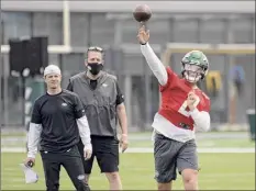  ?? Bill Kostroun / Associated Press ?? Jets QB Zach Wilson passes before offensive coordinato­r Mike Lafleur, left, and passing game specialist Greg Knapp.