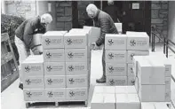  ?? MATT BUTTON/BALTIMORE SUN MEDIA ?? Gus Bengel, left, and Ted Root move Maryland Food Bank boxes Nov. 18 at the Trinity Episcopal Church in Towson.