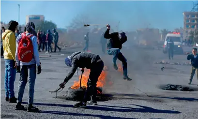  ?? AFP ?? Palestinia­n protesters set a tyre on fire during clashes with Israeli security forces in Ramallah, West Bank, on Tuesday. —